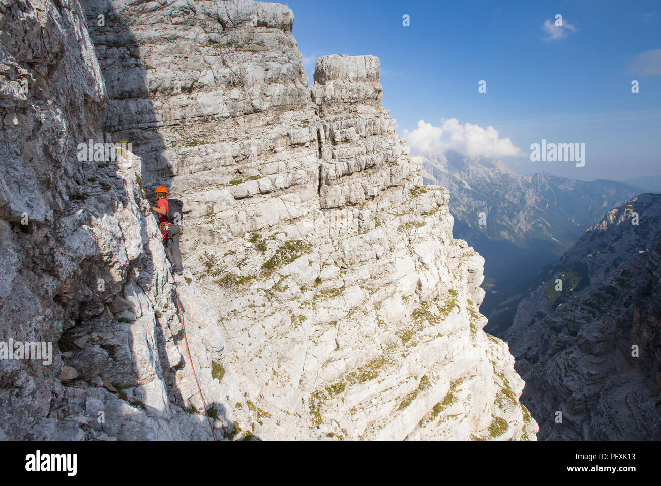 Mountain guide walking along cliff during climb of Triglav, Slovenia Stock Photo