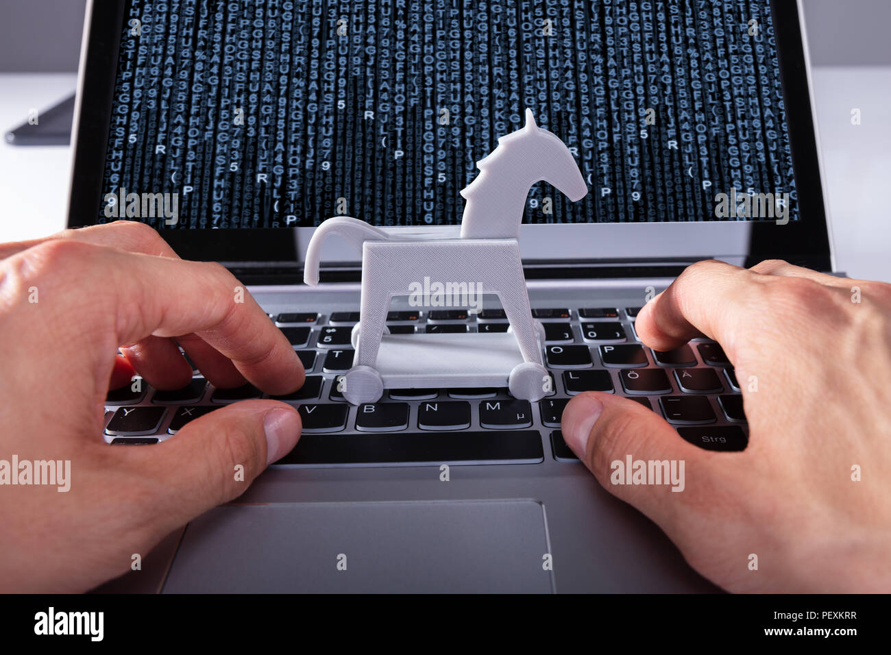 Close-up Of A Person's Hand With Trojan Horse Icon On Laptop Affected By Virus Stock Photo