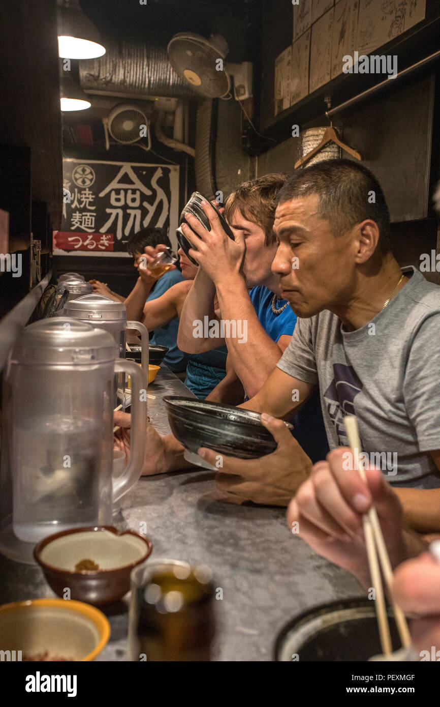 Tourists eating in ramen shop, Tokyo, Japan Stock Photo