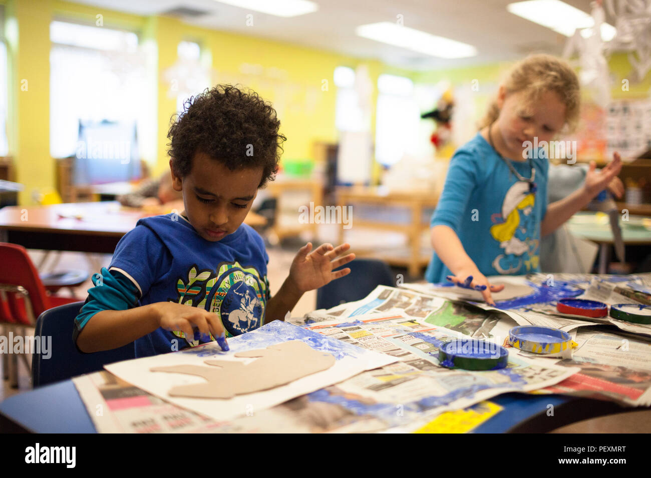 Schoolchildren finger painting in classroom Stock Photo