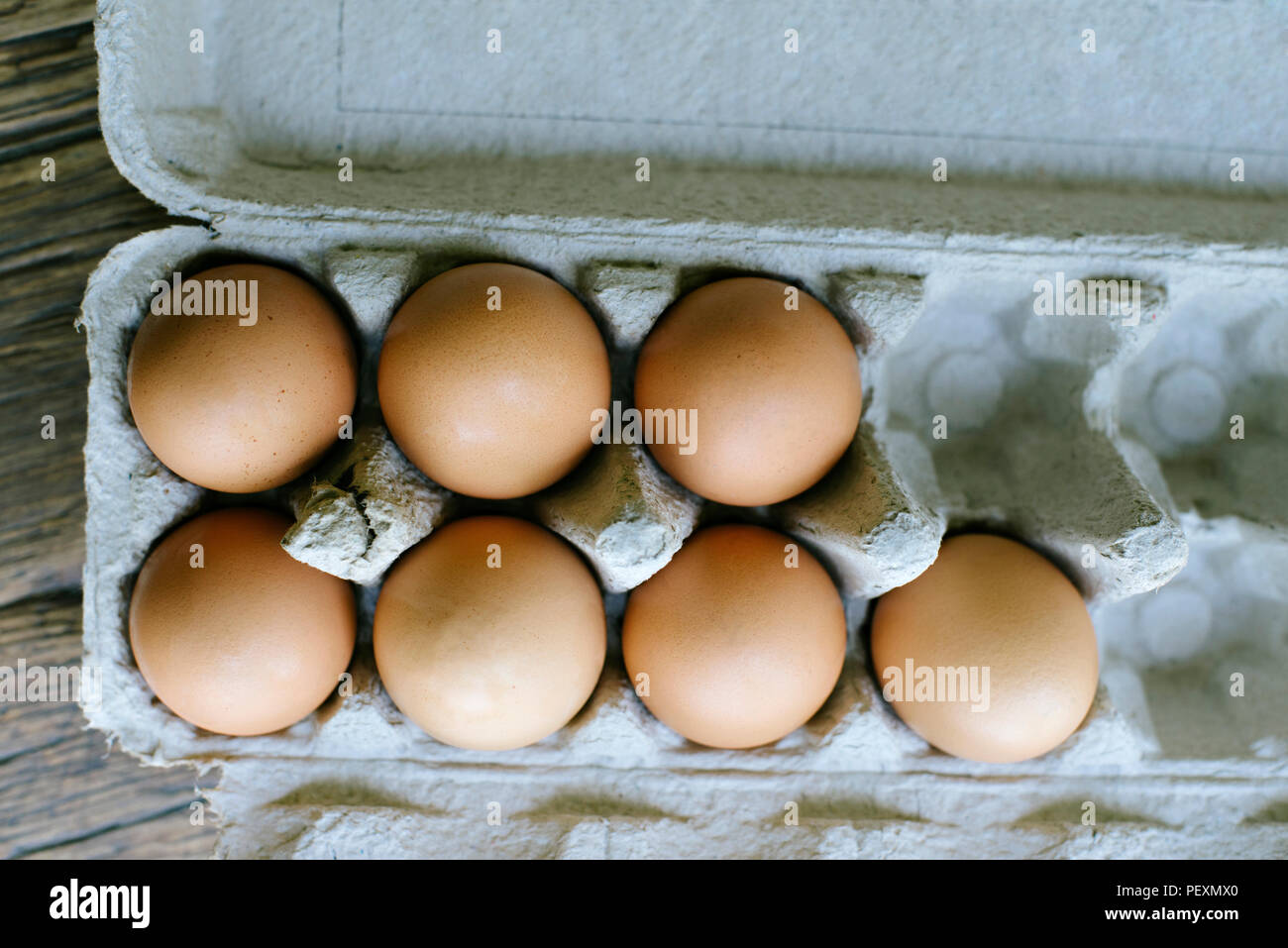 7 fresh brown eggs on a carton ready to use Stock Photo