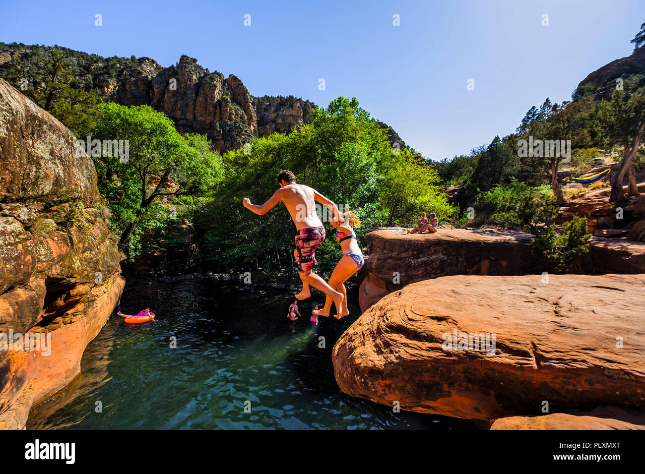 Couple jumping into Beaver Creek, Arizona, USA Stock Photo