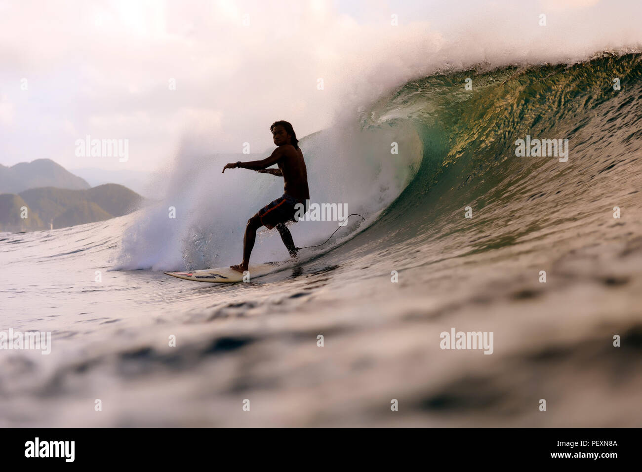 Surfer riding wave in sea Stock Photo