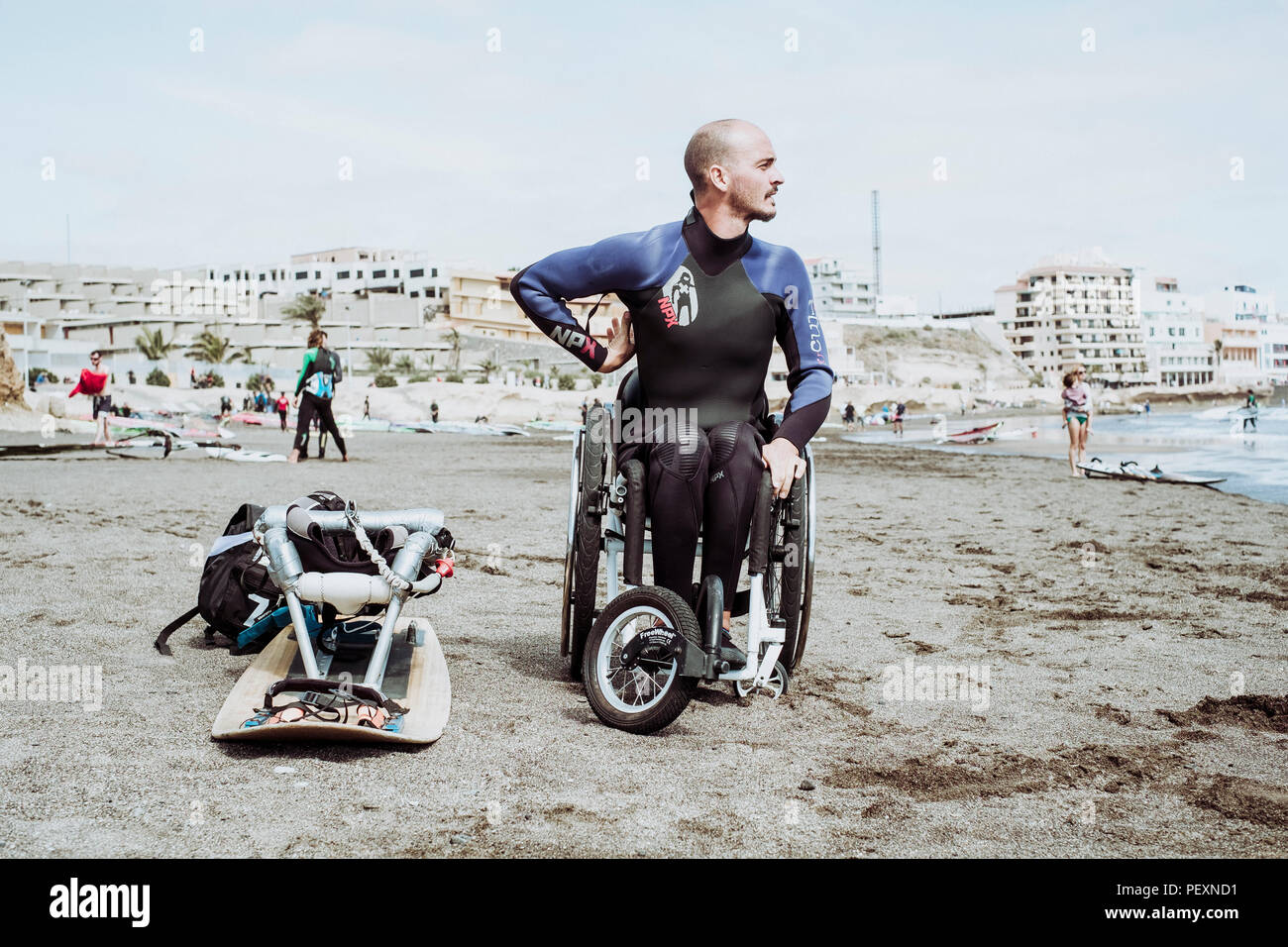 Male disabled kitesurfer in wetsuit on beach, Tenerife, Canary Islands, Spain Stock Photo