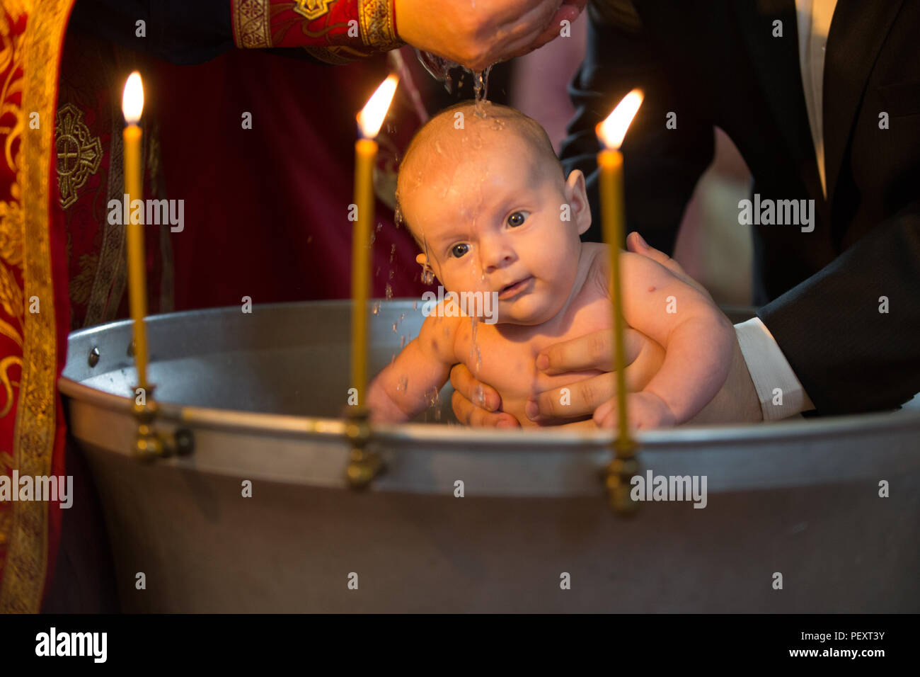 Belarus, Gomel, May 6, 2018. Church of Volotovo. Baptism of a newborn child.Newborn baby baptism by water with hands of priest Stock Photo