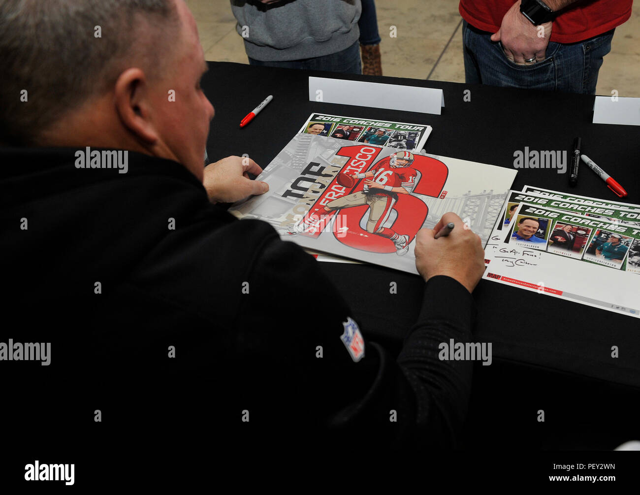 Chip Kelly, San Francisco 49ers head coach, signs his autograph for a fan during the 2016 Coaches Tour Feb. 14, 2016, at Ramstein Air Base, Germany. The coaches took time to travel here to meet with fans, sign autographs and have lunch with wounded warriors. (U.S. Air Force photo/Airman 1st Class Larissa Greatwood) Stock Photo