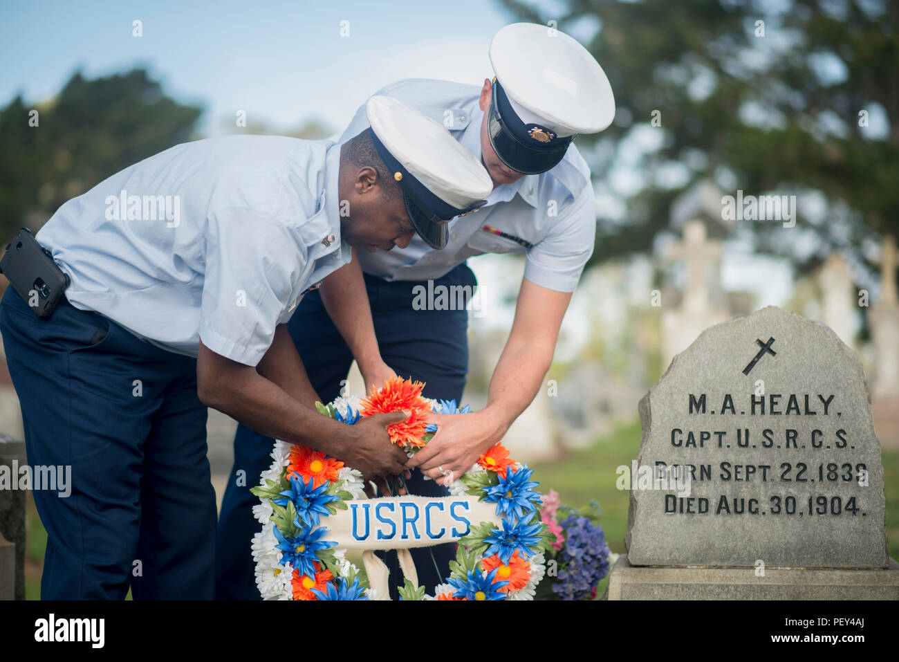 Petty Officer 1st Class Sheldon Williams and Petty Officer 3rd Class Jerry Jones lay a flowered wreath on Capt. Michael Healy's grave in Colma, Calif., Feb. 18, 2016. This observation for Healy's life was in part of District Eleven's Black History Month theme, Hallowed Grounds. (U.S. Coast Guard photo by Petty Officer 3rd Class Adam Stanton) Stock Photo