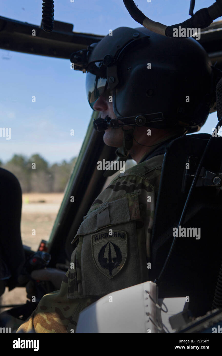 A U.S. Army pilot waits while paratroopers board the UH-60 Black Hawk ...