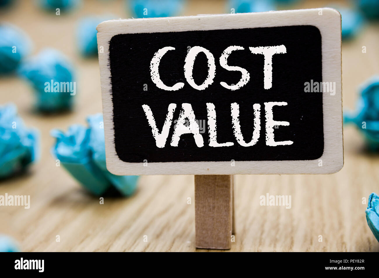 Text sign showing Cost Value. Conceptual photo The amount that usualy paid for a item you buy or hiring a person Blackboard crumpled papers several tr Stock Photo