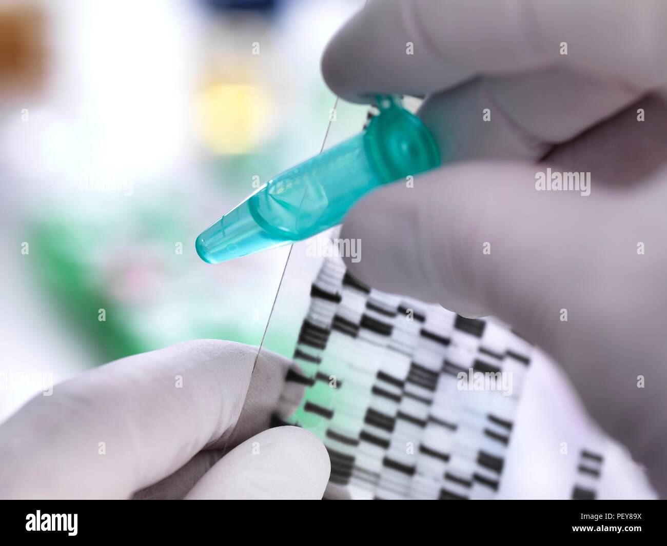 Scientist holding a DNA (deoxyribonucleic acid) sample in a tube with