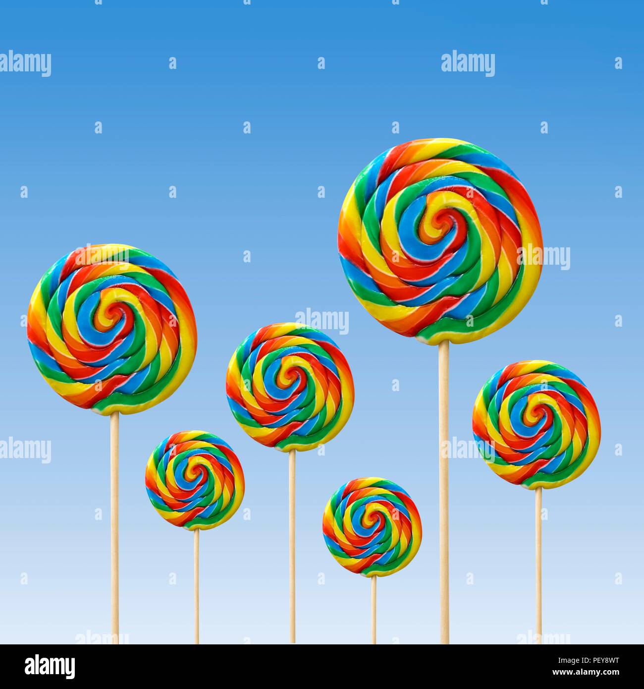 Bright coloured lollipops against a blue background. Stock Photo