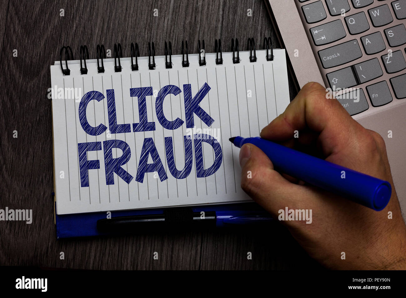 Writing note showing Click Fraud. Business photo showcasing practice of repeatedly clicking on advertisement hosted website Man holding marker spiral  Stock Photo
