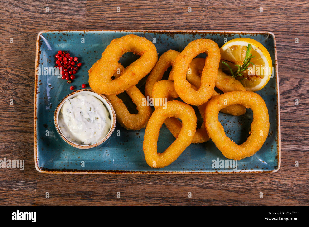 Squid rings with sauce served lemon Stock Photo - Alamy