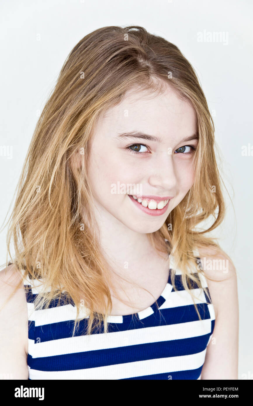 Cute girl eleven years old with blond long hair on white background