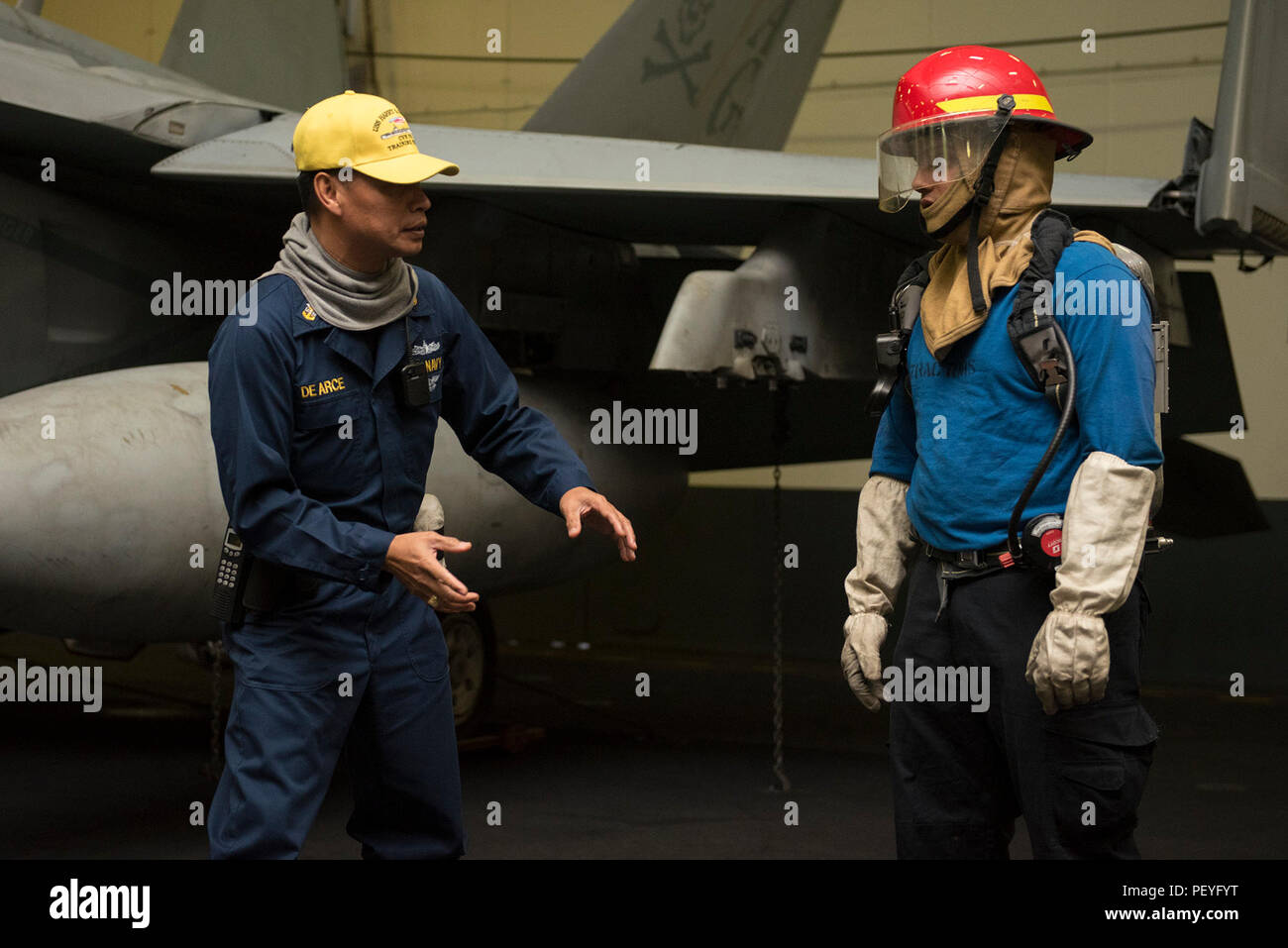160215-N-IG466-037 ARABIAN GULF (Feb. 15, 2016) Master Chief Machinery Repairman Zoilo De Arce, left, trains Aviation Boatswain's Mate (Handling) Airman Abraham Puente how to fight a simulated fire during a general quarters drill in the hangar bay of aircraft carrier USS Harry S. Truman (CVN 75). GQ drills prepare Sailors to be at the highest state of readiness in the event of an emergency. Harry S. Truman Carrier Strike Group is deployed in support of Operation Inherent Resolve, maritime security operations, and theater security cooperation efforts in the U.S. 5th Fleet area of operations. (U Stock Photo