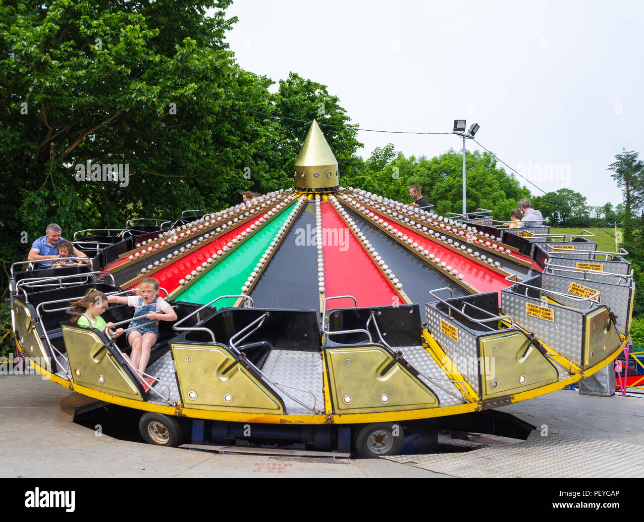 family on summer holiday or vacation on a fairground ride. Stock Photo