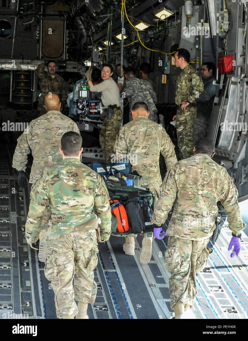 A 455th Expeditionary Medical Group team loads the remaining equipment used to save the life of a NATO ally, who required Extracorporeal Membrane Oxygenation team support, onto an aeromedical evacuation transport at Bagram Air Field, Afghanistan, on Feb. 18, 2016. The ECMO team, dispatched from San Antonio Military Medical Center, uses technology that bypasses the lungs and infuses the blood directly with oxygen, while removing the harmful carbon dioxide from the blood stream. The patient was airlifted to Landstuhl Regional Medical Center, Germany, where he will receive 7 to 14 days of additio Stock Photo