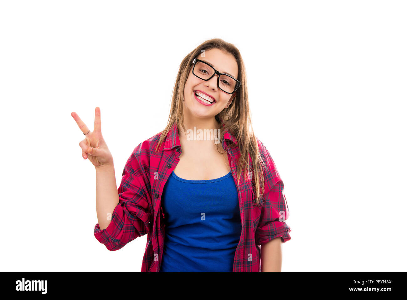 Young happy cool woman in glasses and plaid shirt showing two fingers and smiling at camera isolated on white background Stock Photo