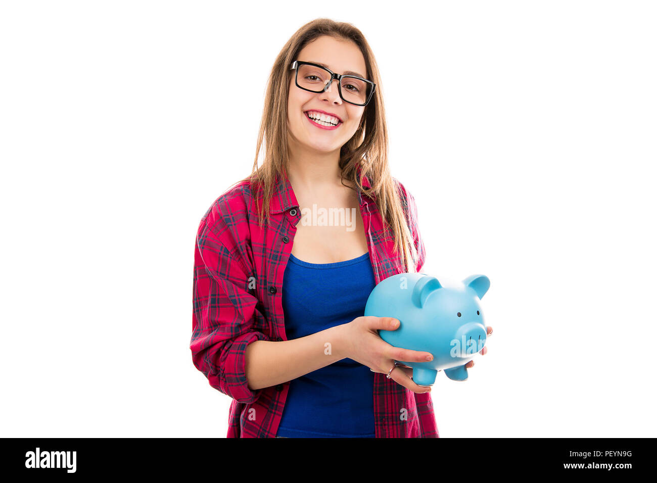 Young happy teen woman in glasses holding blue piggybank with savings for future and smiling at camera isolated on white background Stock Photo