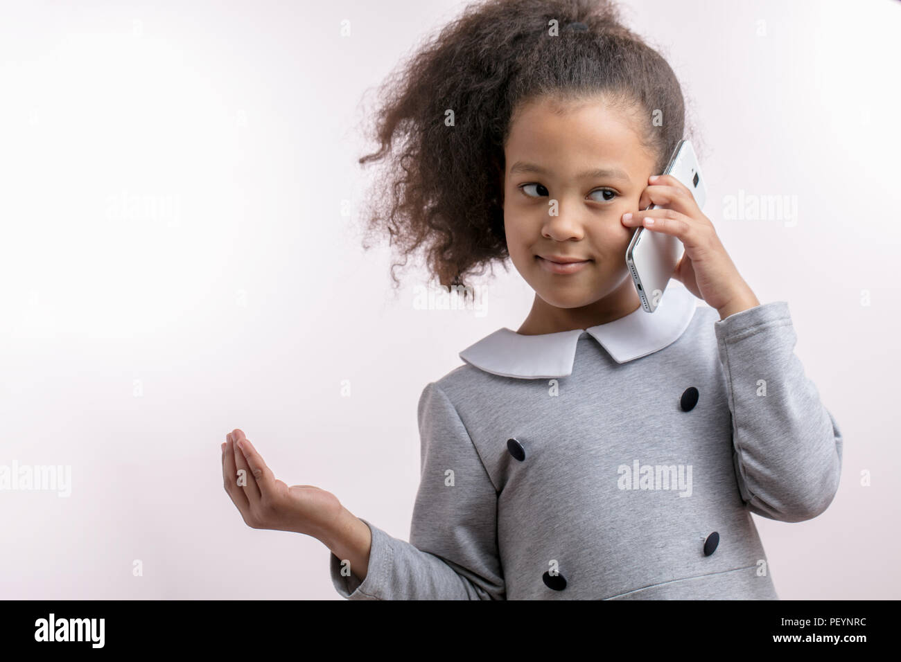 ethicity concept. beautiful lettle girl is talking on the smart phone with a friend.modern technologies Stock Photo