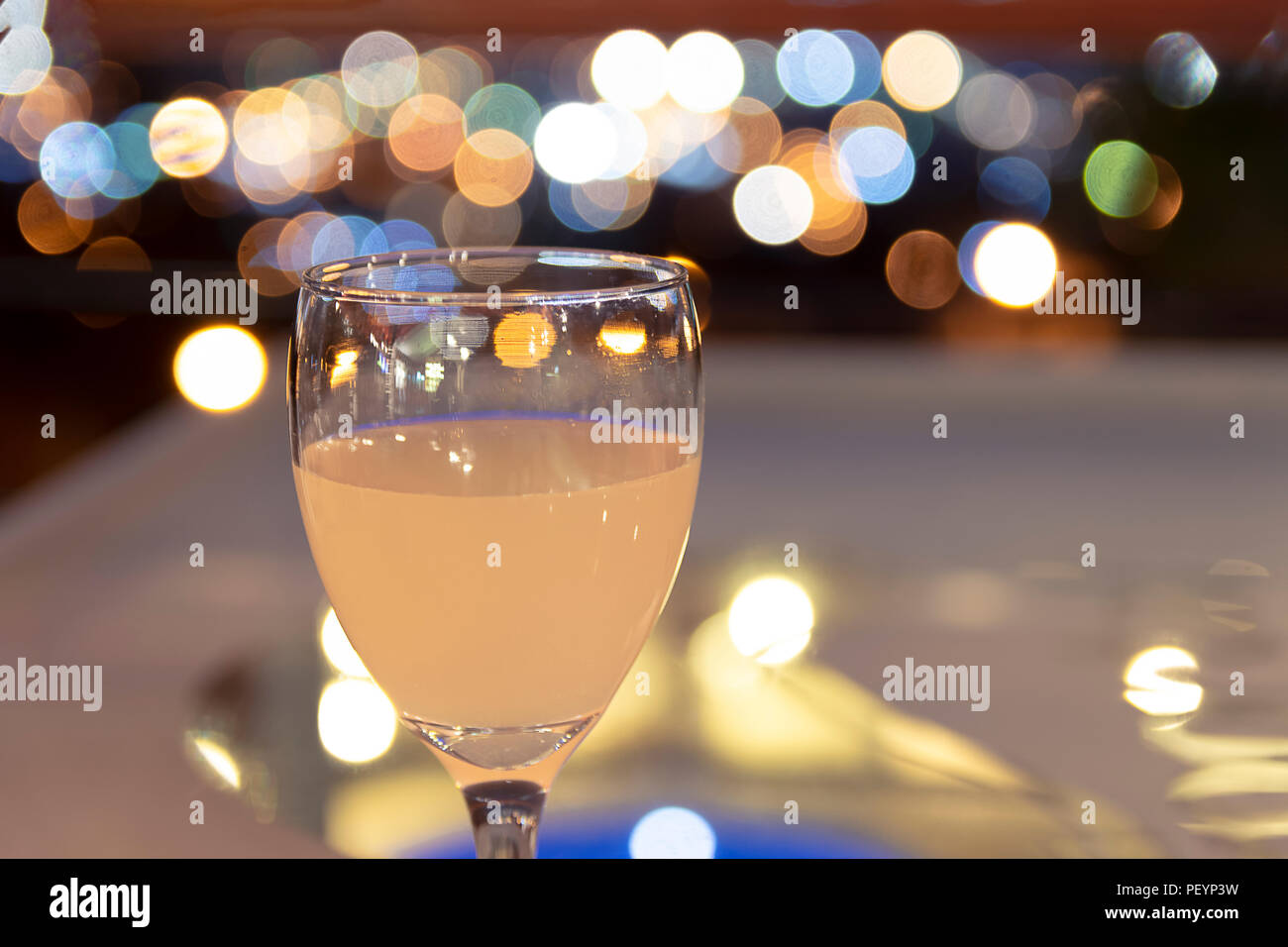 Drink on a table in a restaurant with the view of the ciy lights blurred on the background Stock Photo