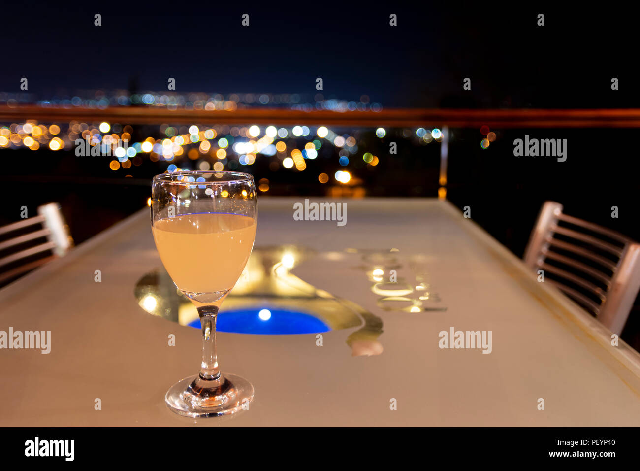 Drink on a table in a restaurant with the view of the ciy lights blurred on the background Stock Photo