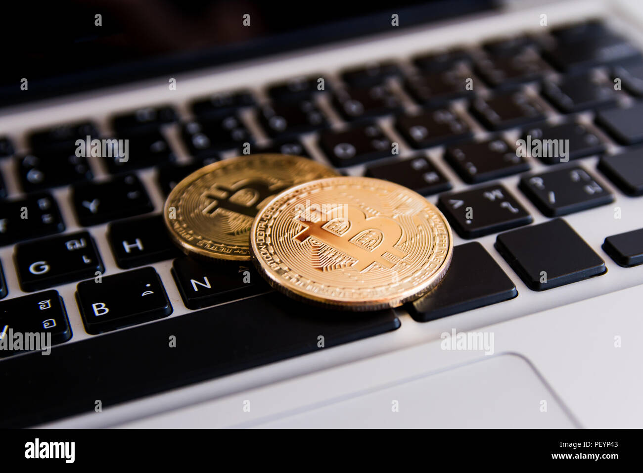 Golden bitcoin coins on keyboard laptop with trading chart background ...