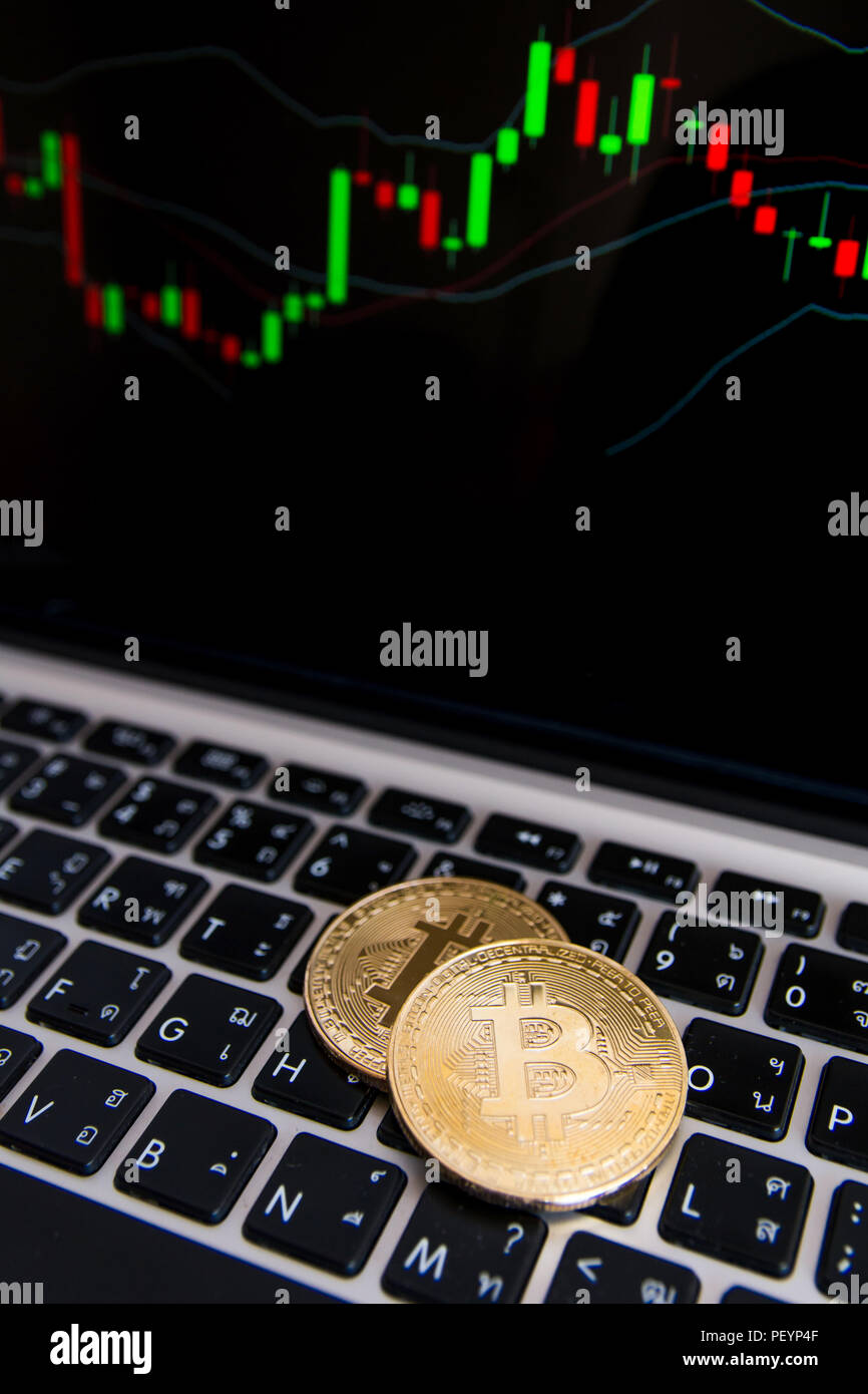 Golden bitcoin coins on keyboard laptop with trading chart background ...