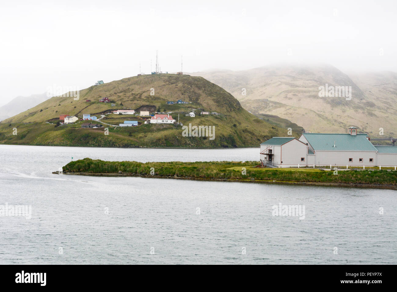 Part of the city of Unalaska, also known as Dutch Harbor, surrounded by mountains and the Bering Sea, Unalaska Island, Aleutian archipelago, Alaska. Stock Photo