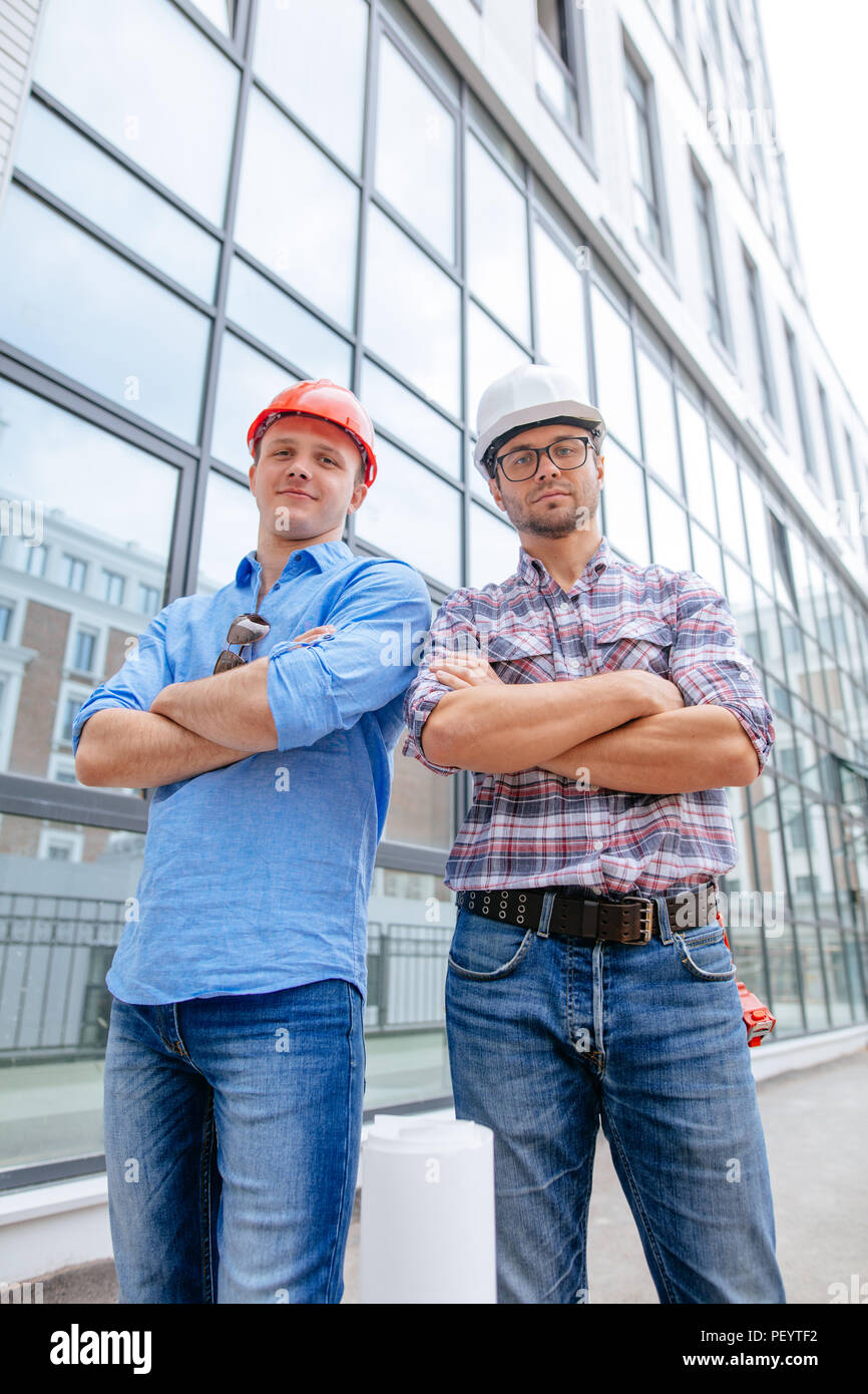 confident architects are standing with folded arms and looking at the camera. occupation concept Stock Photo