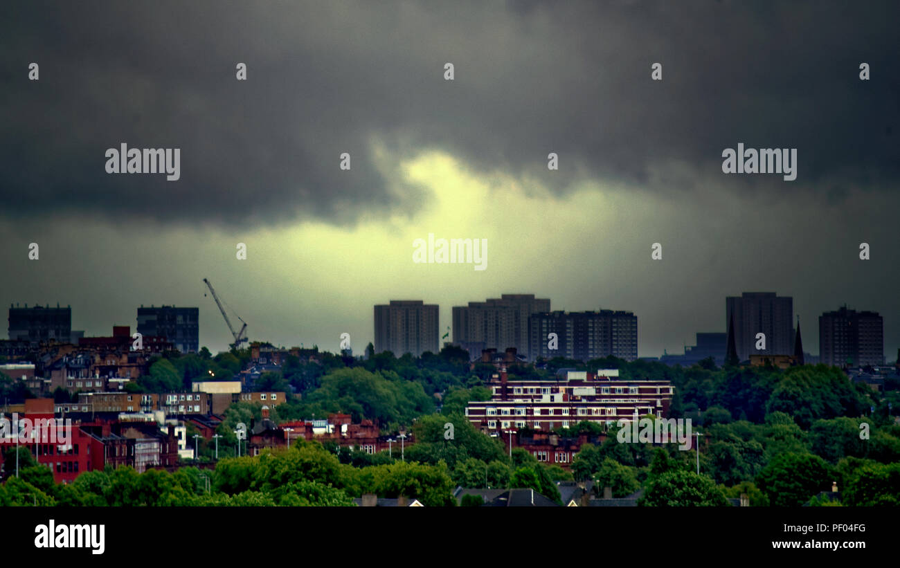 Glasgow, Scotland, UK. 18th August, 2018. UK Weather:Black and gray sky as storm Ernesto is due over the town as overnight rain is forecast through the day.No sky colour with  any sense of perspective comes from the city’s buildings as the sun fails to appear overhead. The leafy suburbs of the west end with the  imposing red bricked foreground art deco kelvin court overlooked by the towers of maryhill and the town 2 miles  further away Gerard Ferry/Alamy news Credit: gerard ferry/Alamy Live News Stock Photo