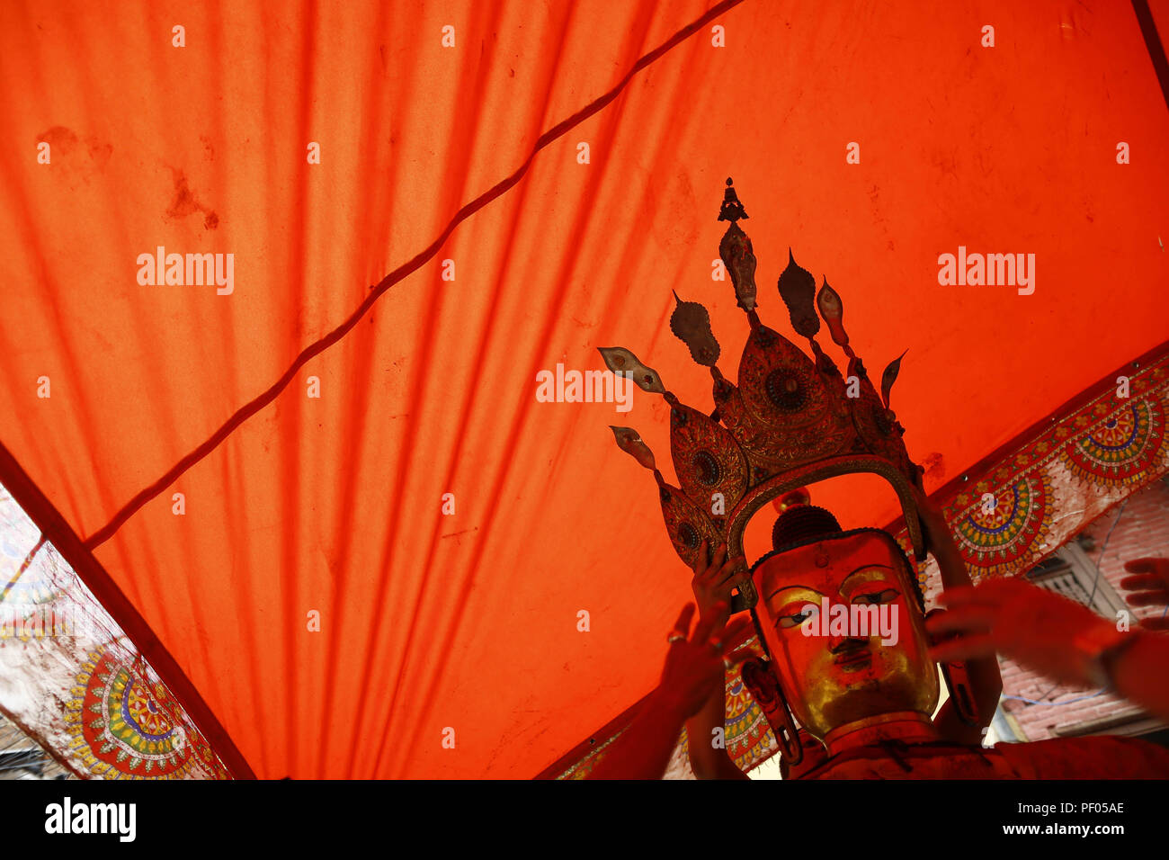 Lalitpur, Nepal. 18th Aug, 2018. Devotees arrange an idol of Deity Dipankar Buddha placed for prayers during Pancha Dan festival in Patan, Lalitpur, Nepal on Saturday, August 18, 2018. The major highlights of the festival are giving away five elements also known as five summer gifts including wheat grains, rice grains, salt, money and fruit. The Buddhists observe Pancha Dan by displacing gigantic antique statues of Deity Dipankar Buddha that are paraded around town Credit: Skanda Gautam/ZUMA Wire/Alamy Live News Stock Photo