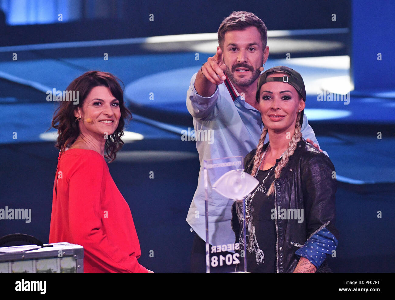 Cologne, Germany. 17th Aug, 2018. Cora Schumacher (r) is on stage alongside the presenters Jochen Schropp and Marlene Lufen at the opening show of the new season of the Sat.1 reality show 'Celebrity Big Brother'. Credit: Henning Kaiser/dpa/Alamy Live News Stock Photo