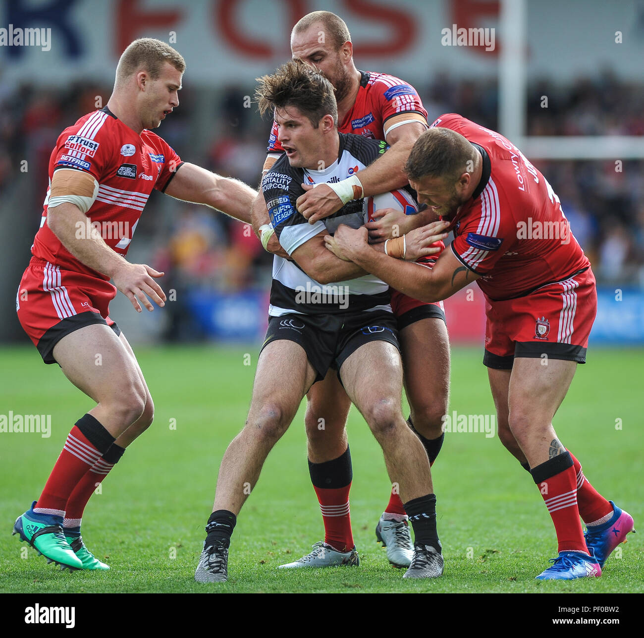 Salford, UK. 18/8/2018. Rugby League Super 8's Salford Red Devils vs Widnes Vikings ; , Widnes Vikings centre Charly Runciman is held by Salford Red Devils defenders at the AJ Bell Stadium, Salford, UK. Dean Williams Stock Photo