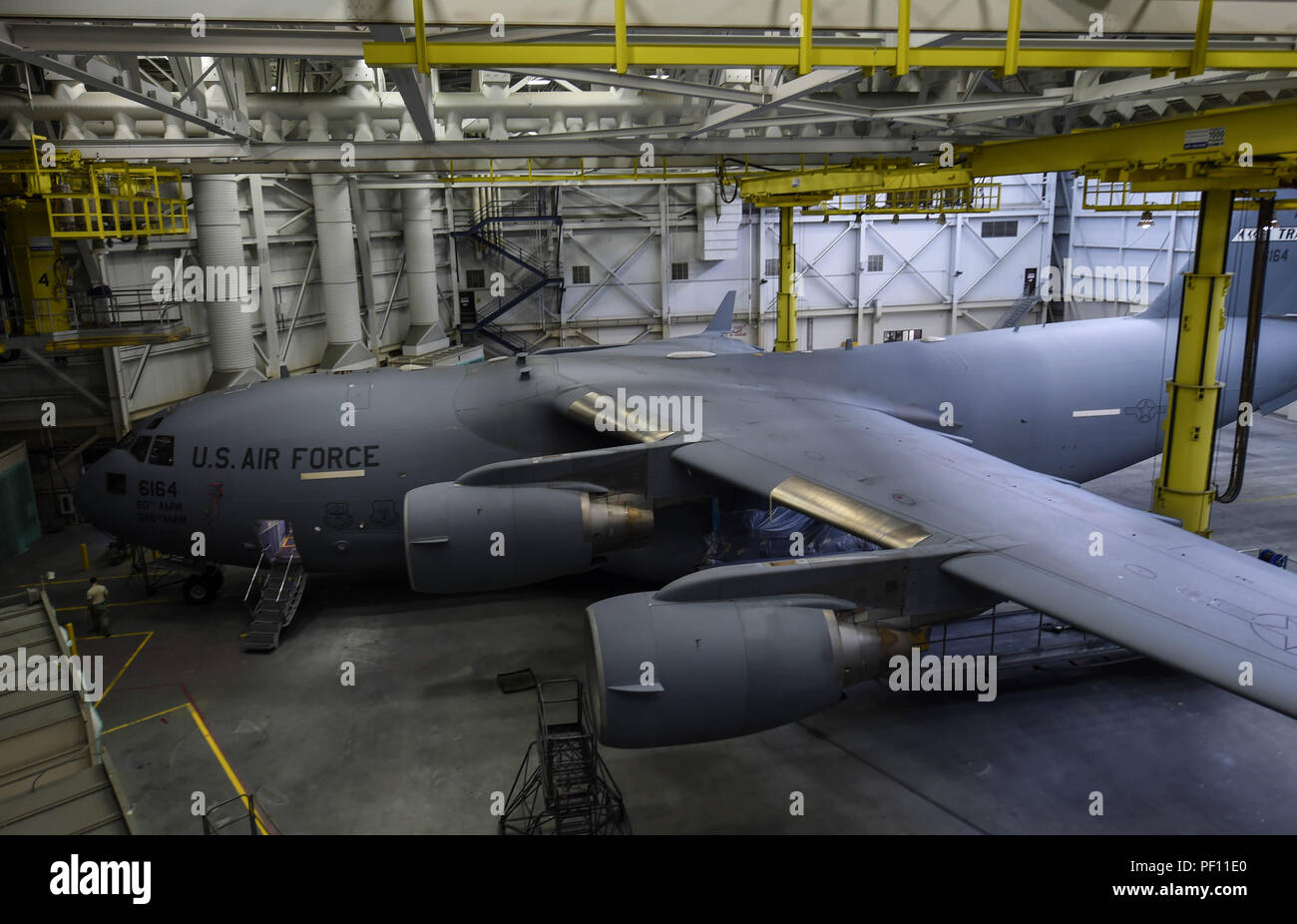 A C-17 Globemaster III from Travis Air Force Base, Calif., sits in a paint barn hangar for paint touch-ups Aug. 6, 2018, at Joint Base Lewis-McChord, Wash. California laws prevent Travis Airmen from spray-painting their C-17s, so they brought it to McChord where it is allowed. (U.S. Air Force photo by Senior Airman Tryphena Mayhugh) Stock Photo