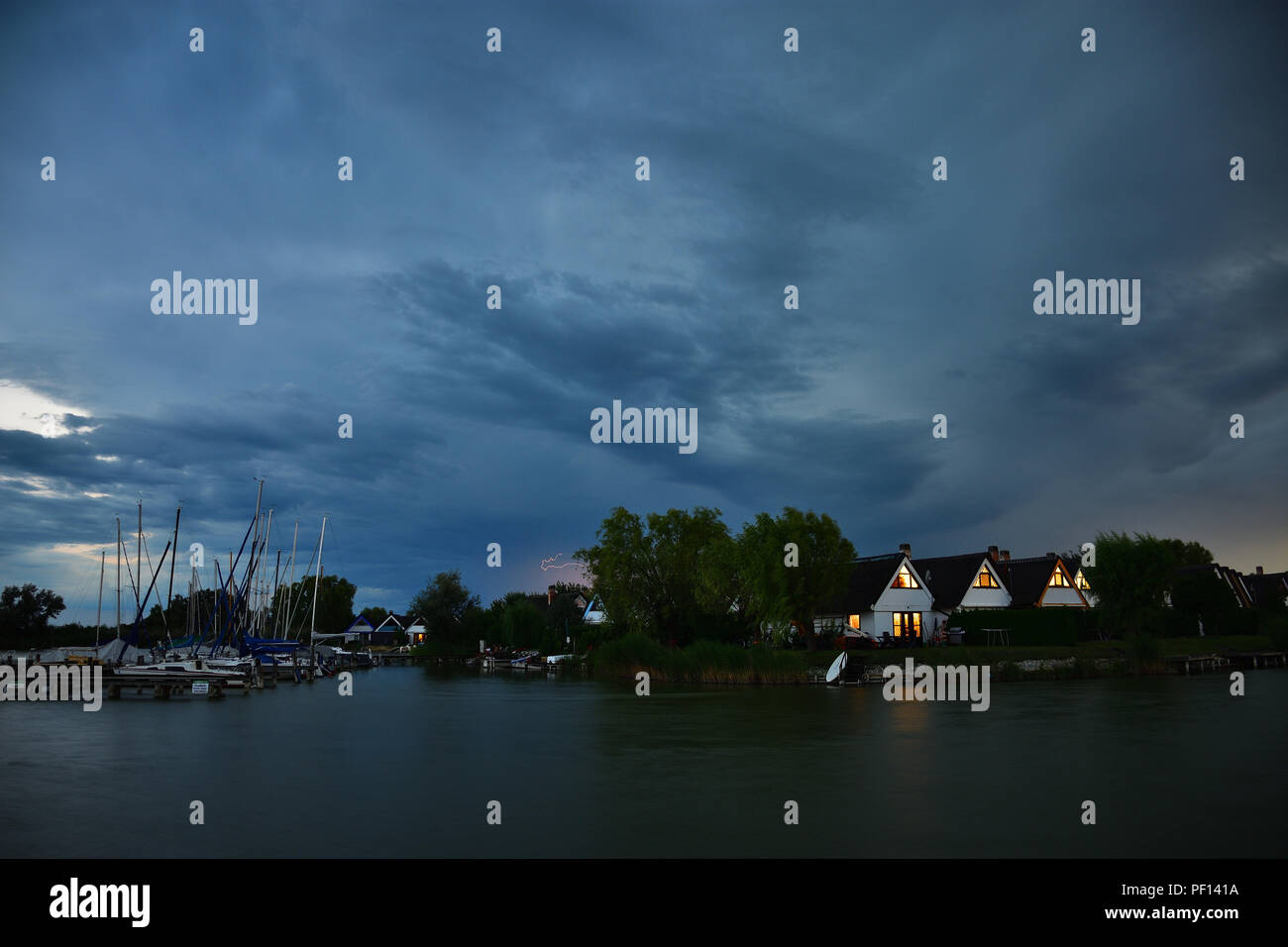 Evening mood with storm cloud over a cottage settlement at Lake Neusiedlersee in Burgenland, Austria. Stock Photo