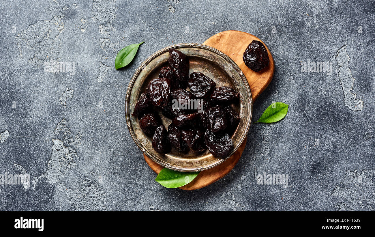 Dried prunes on plate. Top view of peeled plums. Top view Stock Photo