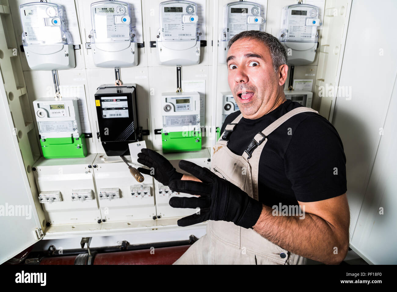Funny electrician doing repair in switchboard or electricity meter Stock Photo