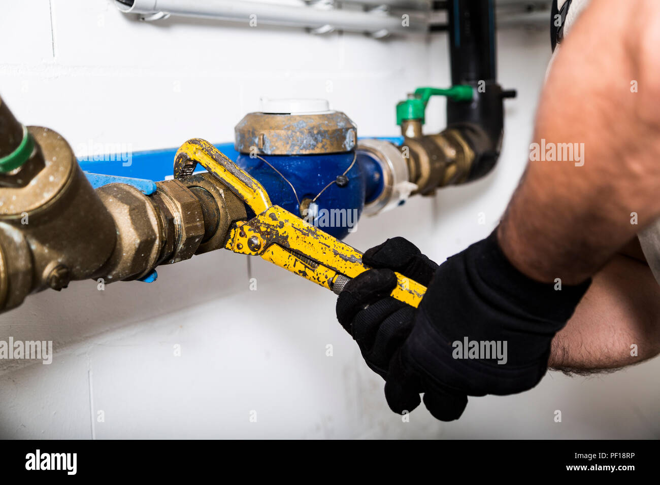 Plumber repairing metallic water pipes with manometer Stock Photo