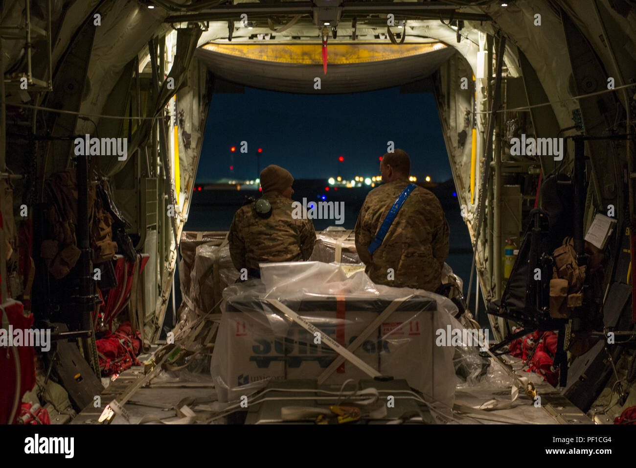 Senior Airman Alec Flores, 455th Expeditionary Aircraft Maintenance Squadron crew chief, and Staff Sgt. Eric Mingues, 455 EAMXS flying crew chief, talk in the back of a C-130J Super Hercules before a night sortie at Bagram Air Field, Afghanistan, Feb. 22, 2016. The 455th EAMXS ensures that aircraft at Bagram are prepared for flight and return them to a mission-ready state once they land. (U.S. Air Force photo/Tech. Sgt. Robert Cloys) Stock Photo