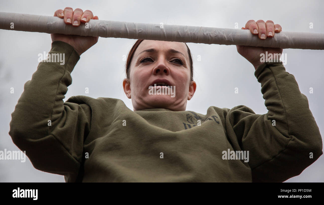 Major Misty Posey demonstrates proper form for pull ups to Marines