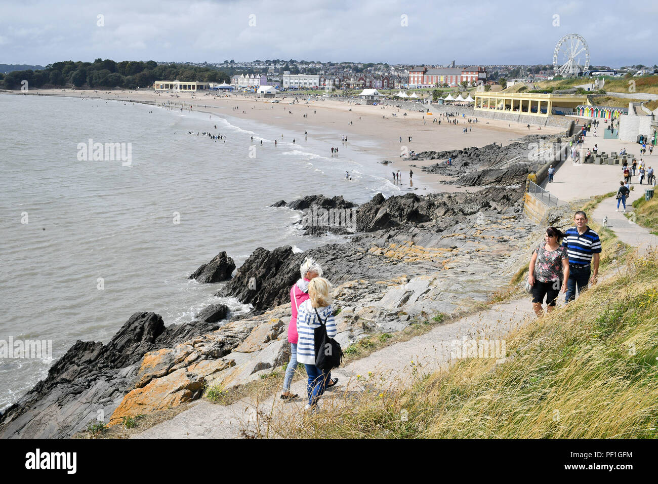 People take a walk on the coast path by the sea at Barry Island, Vale