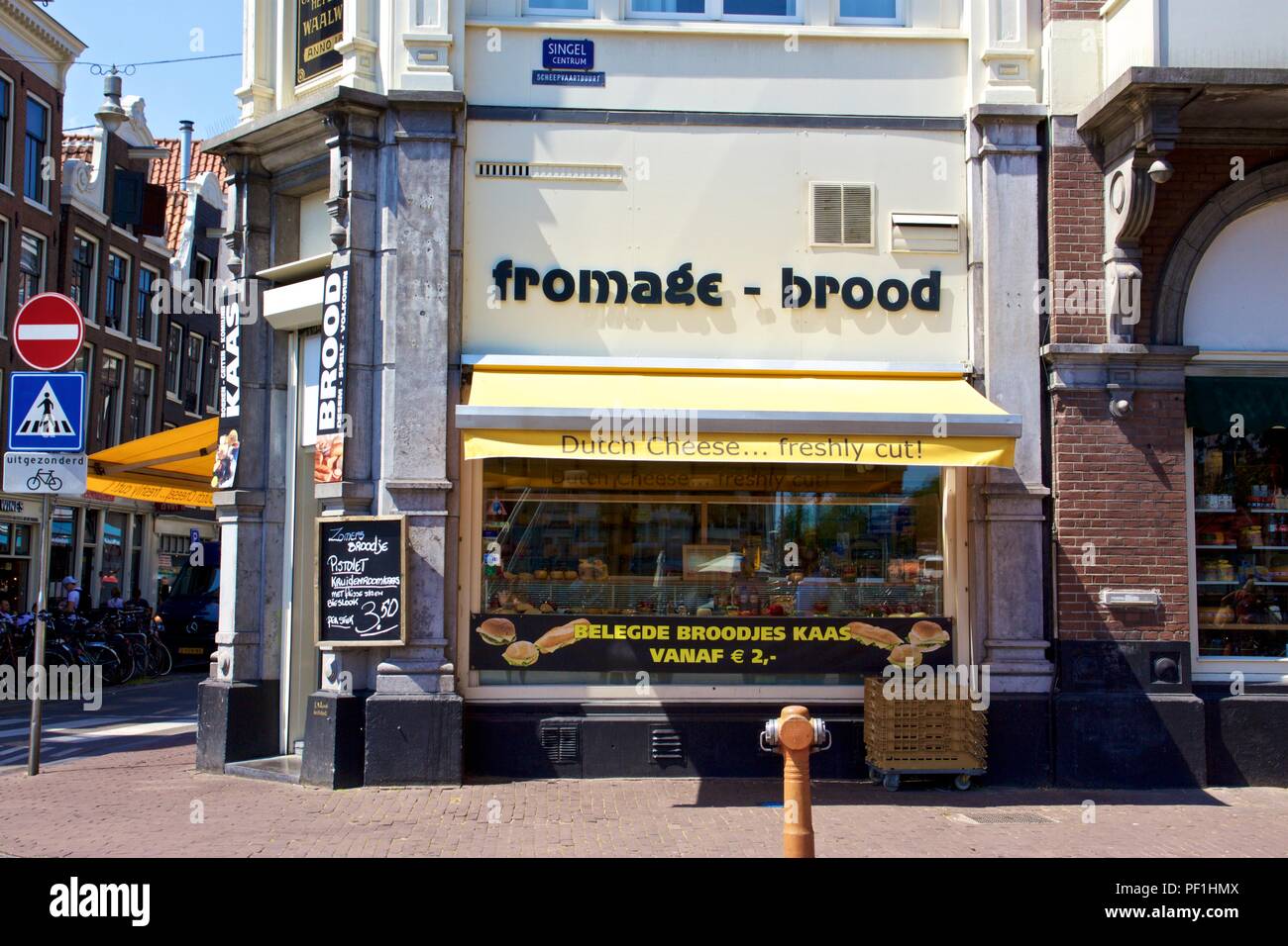 A Dutch Cheese shop with a yellow shopfront advertising 'fromage - brood' on Singel, Amsterdam, the Netherlands Stock Photo