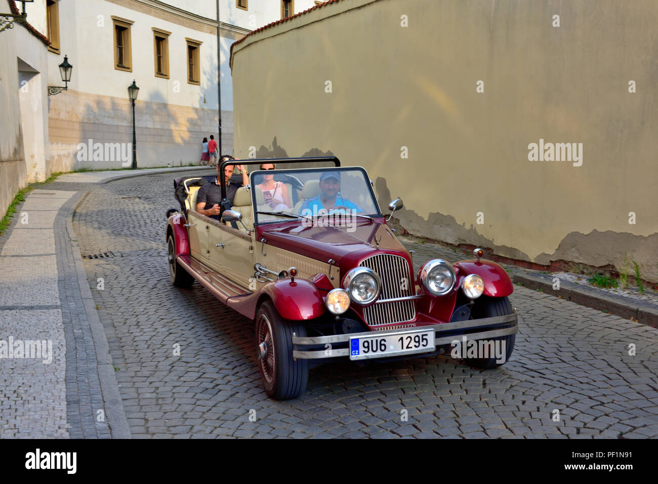 Tourists sightseeing on tour of Prague in old time chauffeur driven vintage cars, Czech Republic Stock Photo