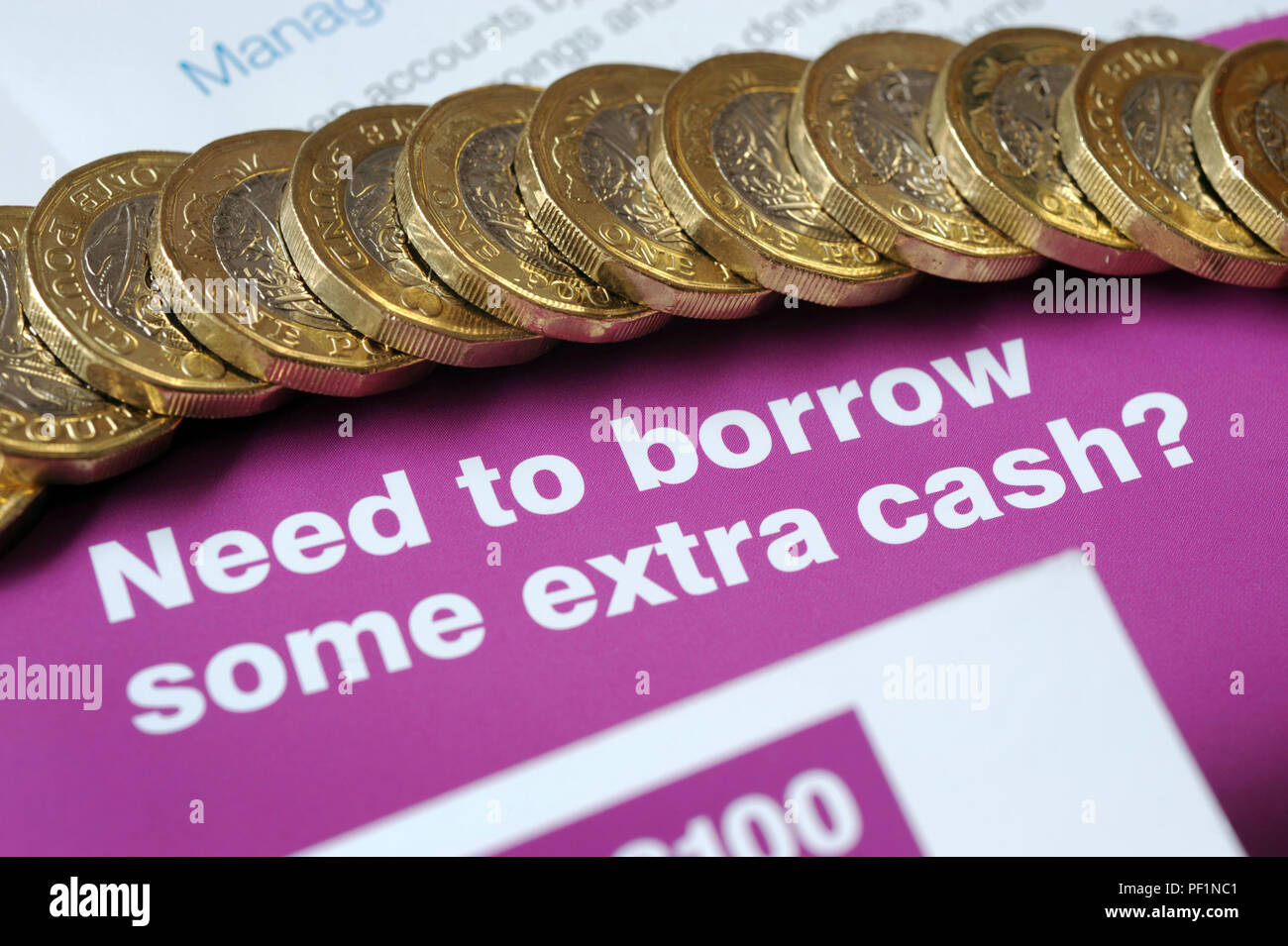 LOAN LEAFLETS WITH ONE POUND COINS RE BORROWING SHORT TERM LOANS PAYDAY APR EXTRA CASH UK Stock Photo