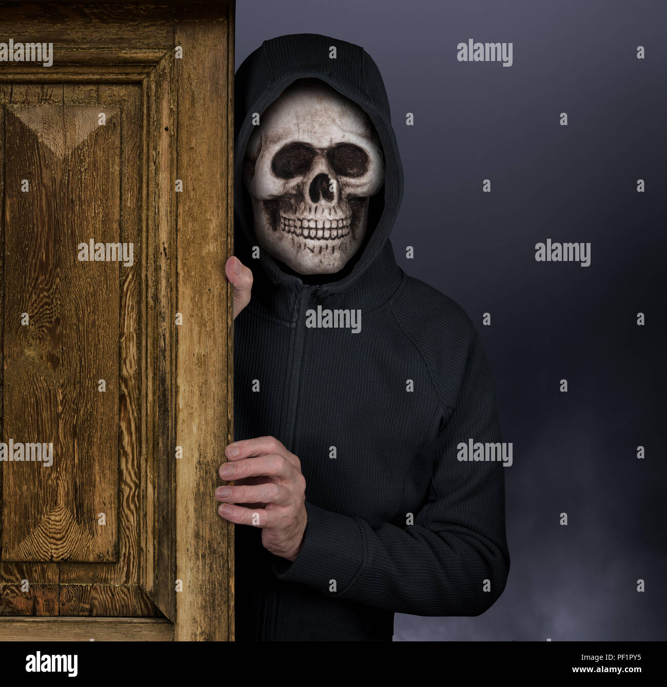 Halloween theme of man with skull mask welcoming to haunted house Stock Photo