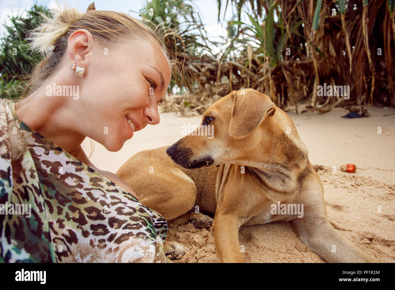 Selfy with dog and smiling girl on the beach of Sri Lanka Stock Photo