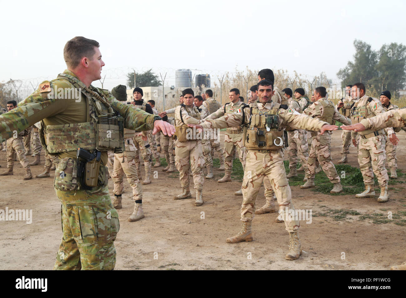 An Australian soldier with Task Group Taji leads physical training with Iraqi soldiers assigned to the Junior Leaders Course (JLC) at Camp Taji, Iraq, Jan. 2016. JLC students then went through