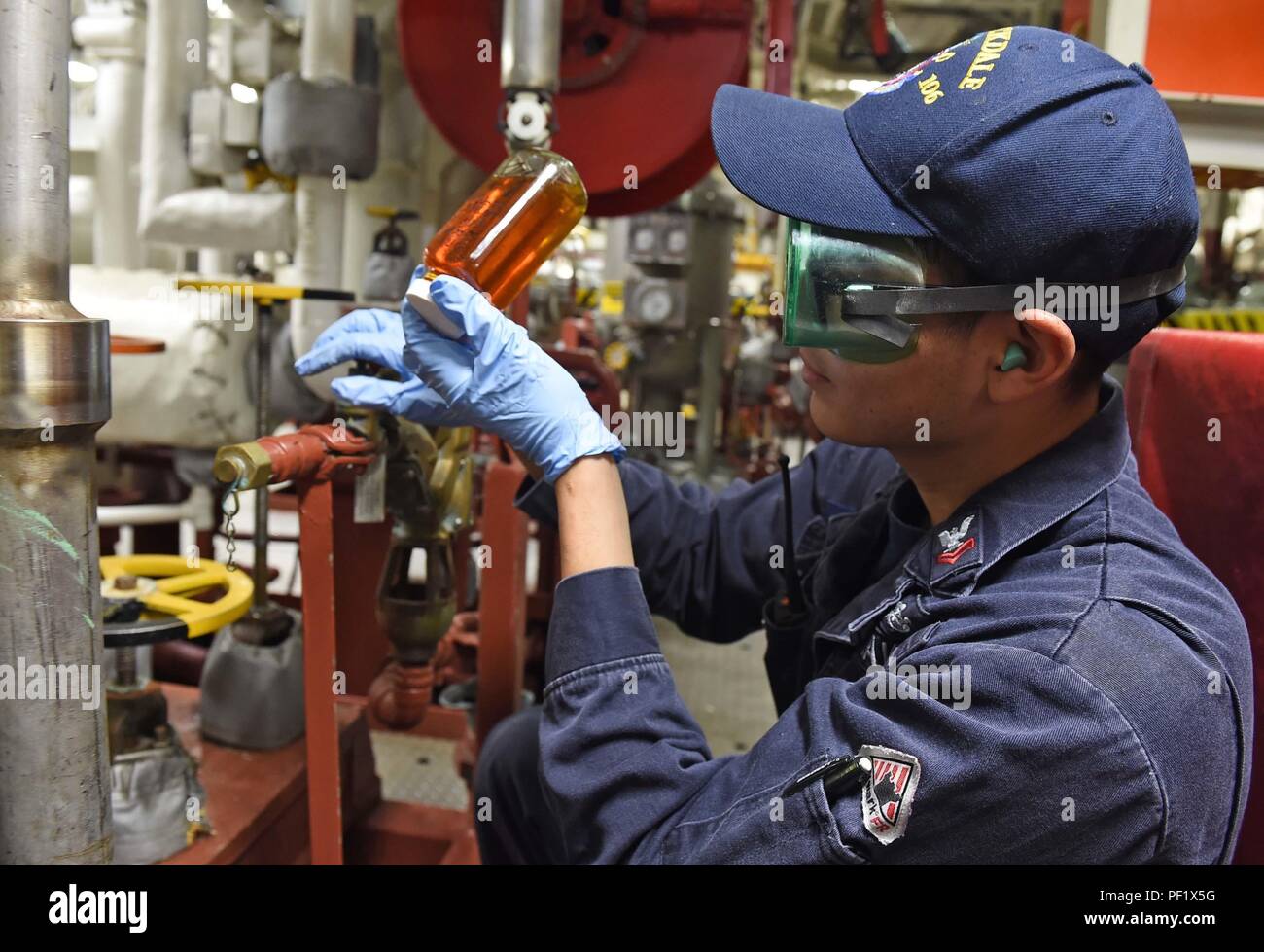 160222-N-KM939-471  PHILIPPINE SEA (Feb. 22, 2016) - Gas Turbine Systems Technician (Mechanical) 2nd Class Enrique Martinezcarballo, from Visalia, Calif., checks a sample of lube oil for contaminents aboard the guided-missile destroyer USS Stockdale (DDG 106). Providing a ready force supporting security and stability in the Indo-Asia-Pacific, Stockdale is operating as part of the John C. Stennis Strike Group and Great Green Fleet on a regularly scheduled 7th Fleet deployment. (U.S. Navy photo by Mass Communication Specialist 3rd Class David A. Cox/Released) Stock Photo