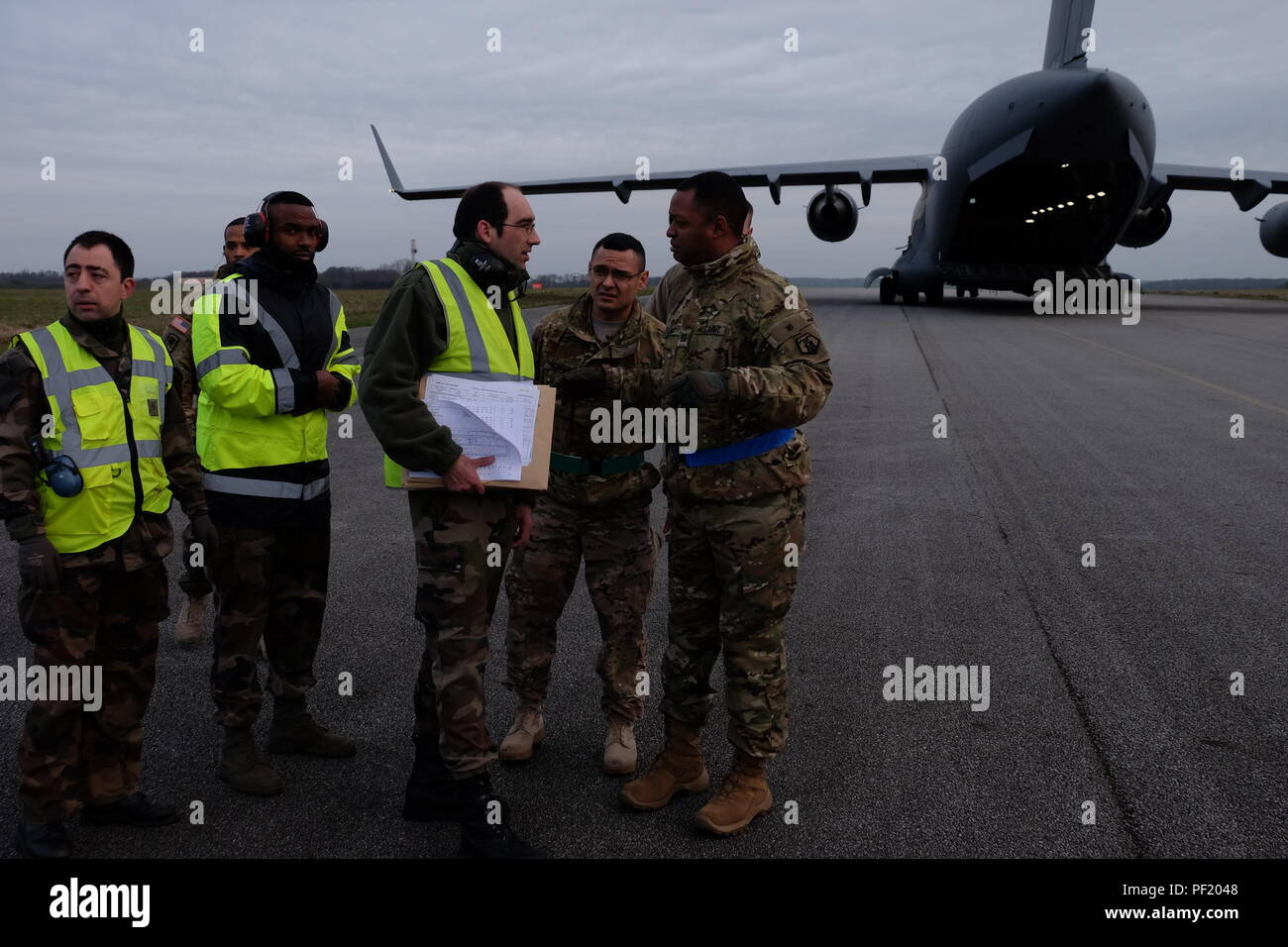 French Air Force movement control team members, left,  and 7th Mission Support Command Soldiers, U.S. Army Reserve Sgt. 1st Class Joaquin Rendon, center, the noncommissioned officer in charge and joint inspector from the 446th Transportation Battalion (Movement Control), and U.S. Army Reserve Capt. Korey Lewis, officer in charge and joint inspector and the commander of the 793rd Movement Control Team, 446th Trans. Bn., conduct joint partnered movement control operations with their French counterparts and U.S. Air Force personnel Feb. 22, 2016, in support of United States Africa Command’s Opera Stock Photo